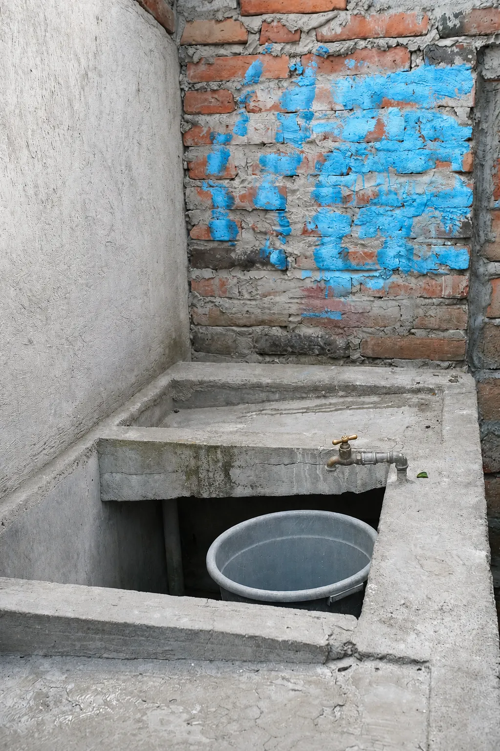 Área de lavandería con lavadero de cemento, llave de agua y tina para lavar a mano
